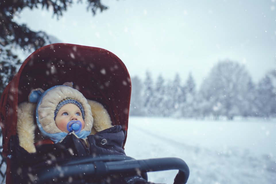 Bébé dans sa poussette sous la neige 