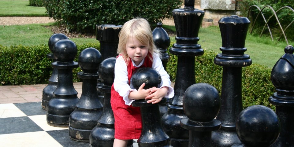 Fillette sur un jeu d'échecs géant