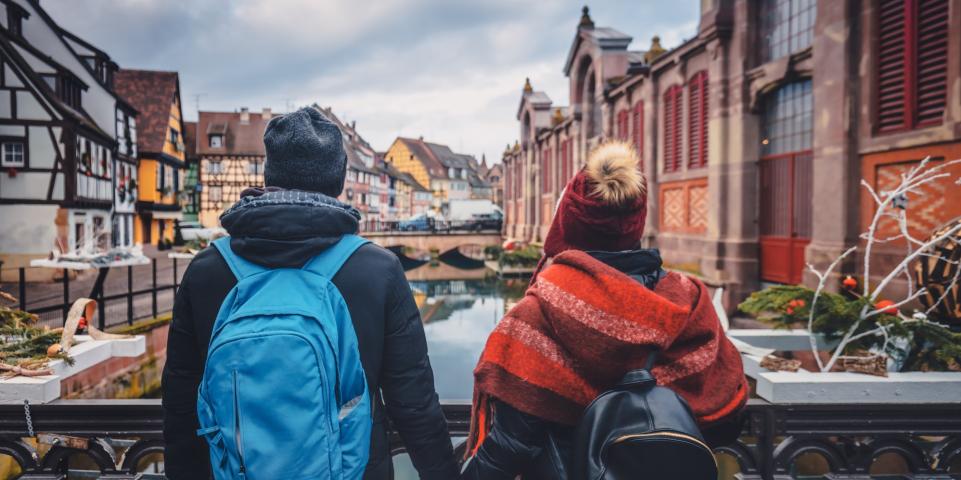 Couple romantique se tenant par la main devant les canaux à Colmar 