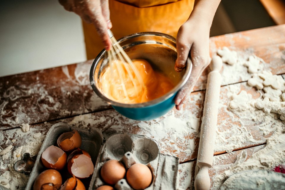 Personne qui cuisine avec des jaunes d'oeufs et de la farine
