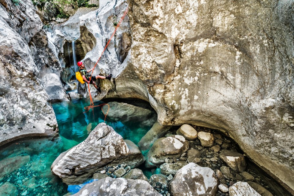 homme équipé descente en rappel canyoning dans une piscine naturelle