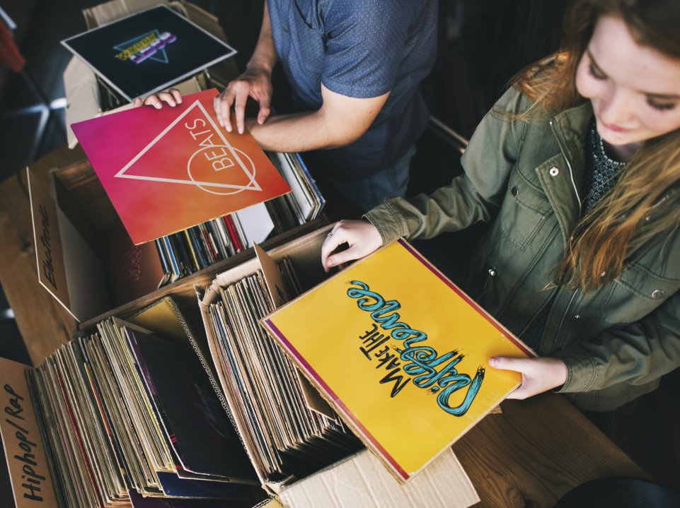 Femme attrapant un disque dans un bac à vinyles 
