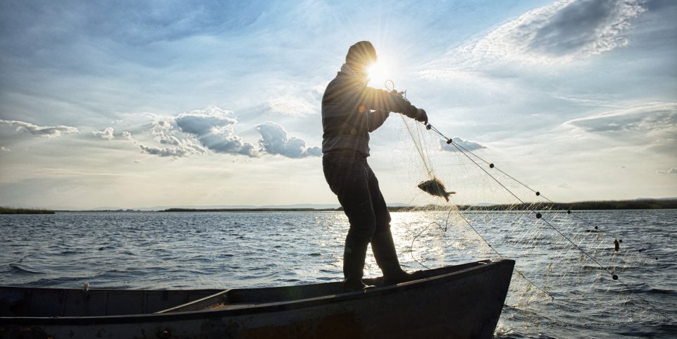 Pêcheur sur une barque en mer