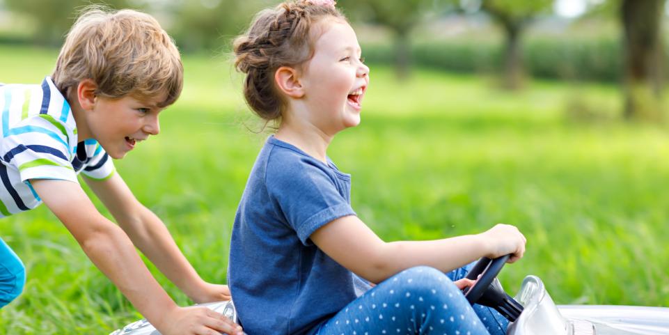 deux enfants dans une voiturette qui rigolent
