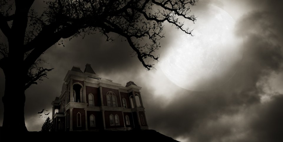 Maison hantée derrière un arbre dans la nuit