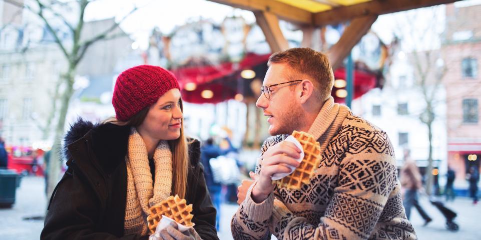 Couple mangeant des gaufres sur un marché de Noël
