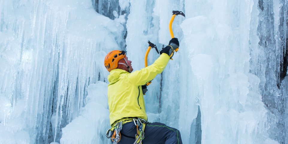 Une homme escalade mur de glace