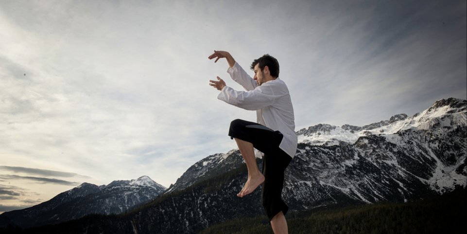 Homme faisant du taï-chi à la montagne 