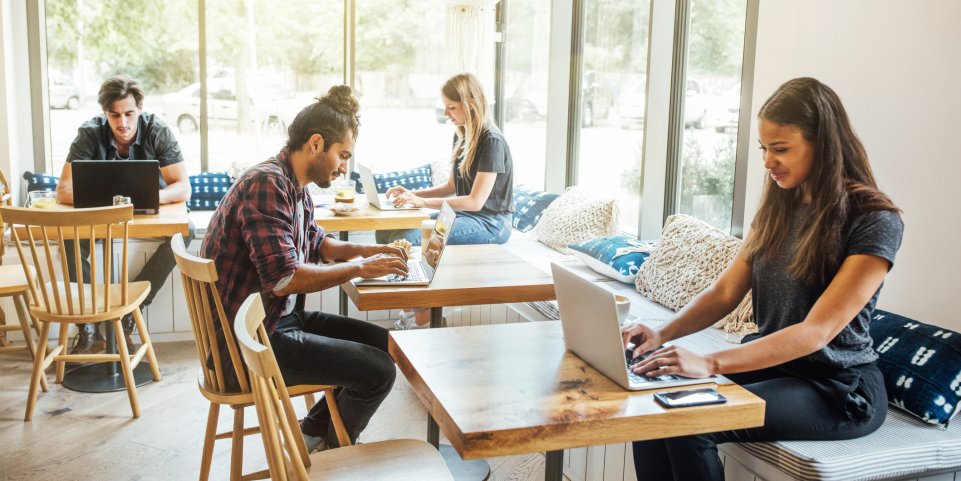 Des jeunes travaillent dans un café sur leur ordinateur