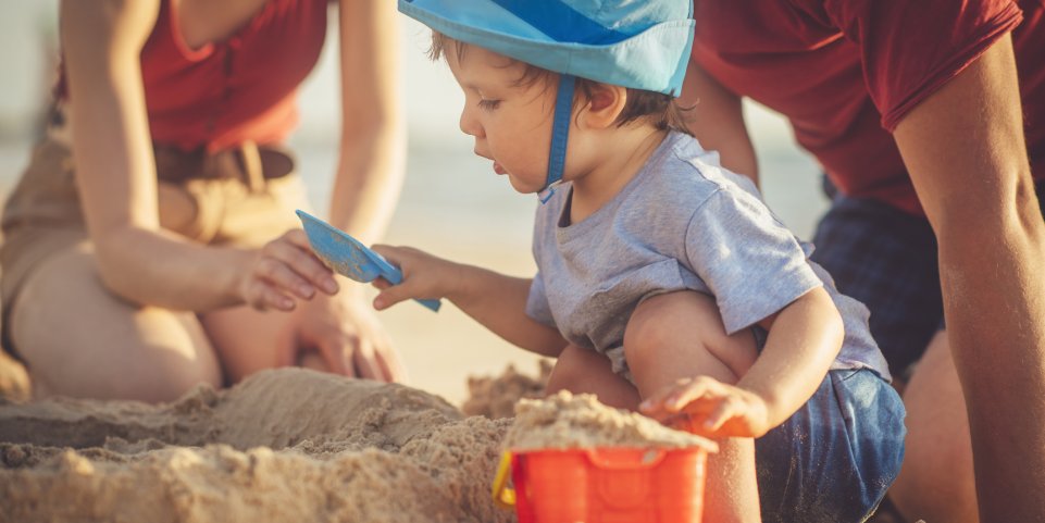 Un enfant construit un château de sable