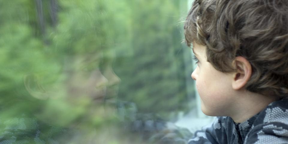 enfant devant une fenêtre d'un wagon de TGV train service Junior & Cie