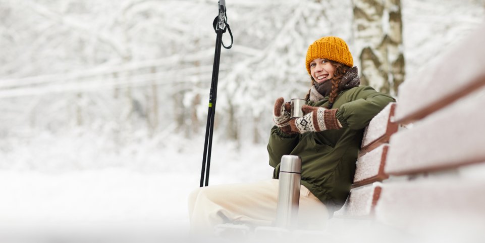 Une femme boit un café aux sports d'hiver