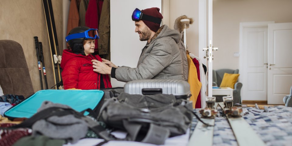 Un père et son fils s'habillent pour aller skier