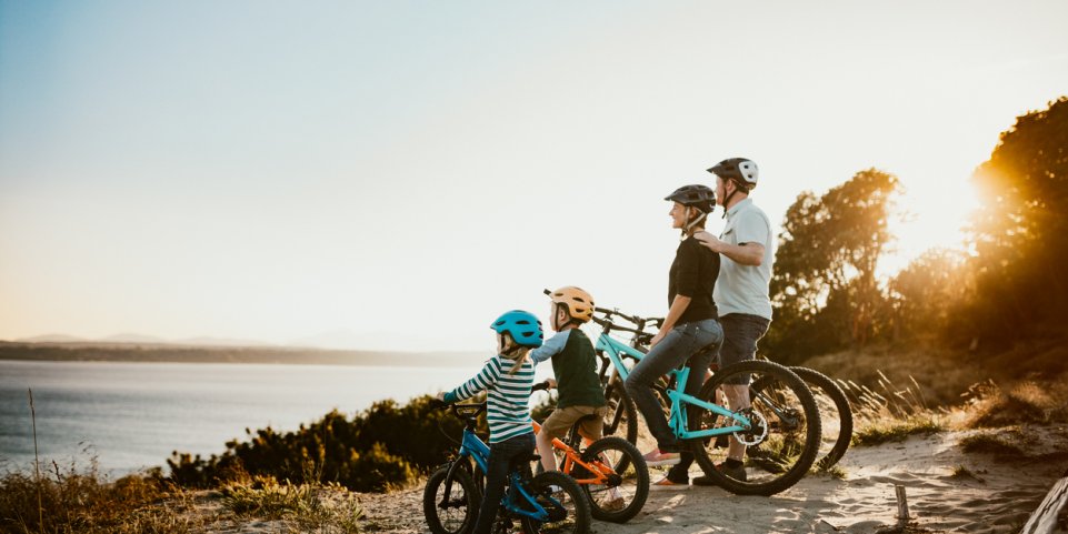 Famille en vélo en bord de plage