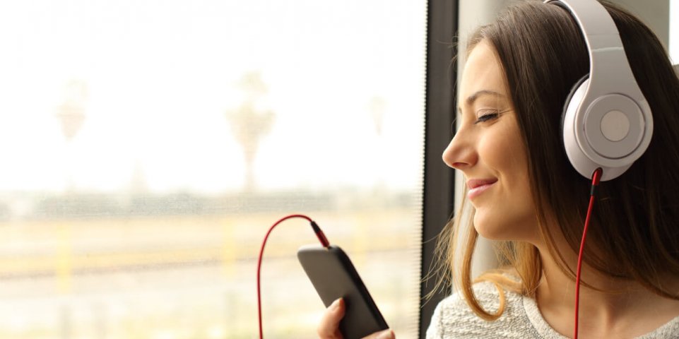 Jeune femme écoutant de la musique avec son casque dans le train