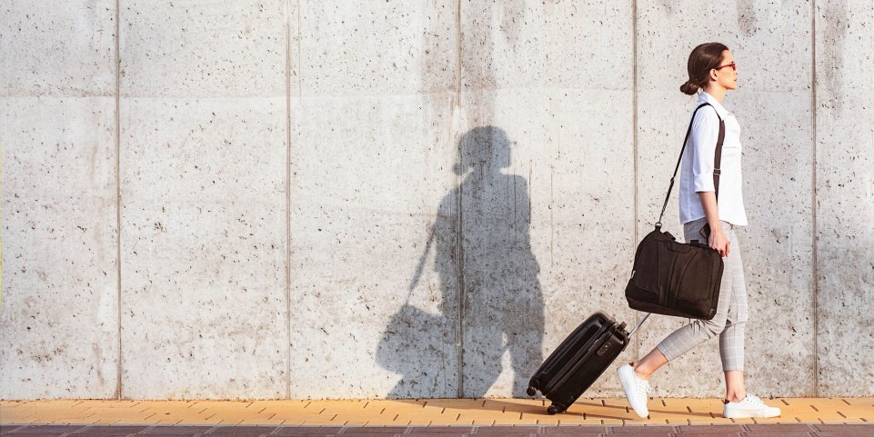 Femme qui marche avec une valise
