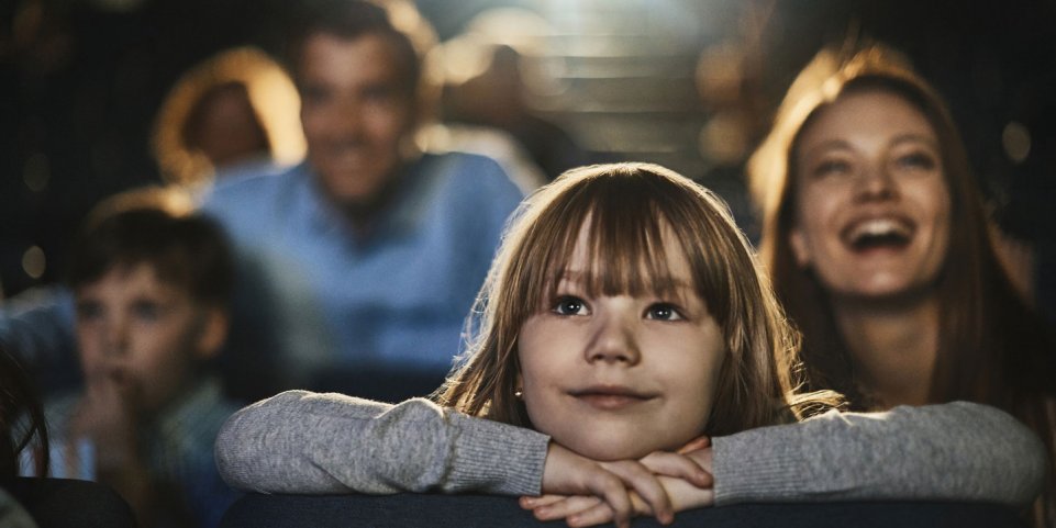 Famille devant un film dans une salle de cinéma