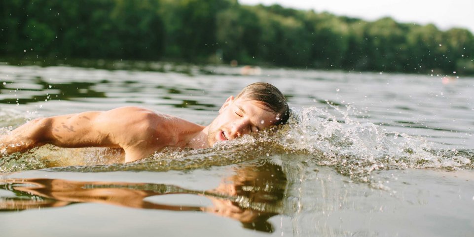 homme nage dans un lac 