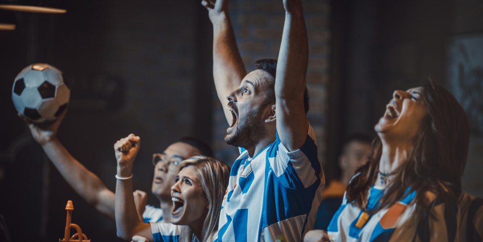 Groupe d'amis devant un match dans un bar 