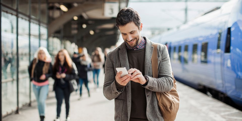 Train homme smartphone gare