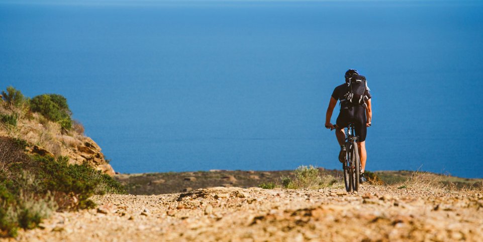 Un homme en VTT au bord de la Méditerranée
