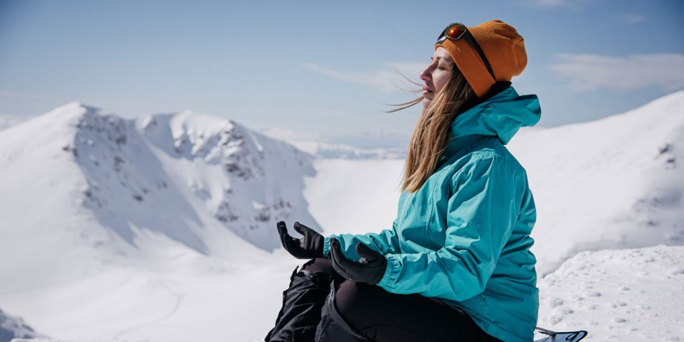 Femme dans la neige pratiquant le yoga