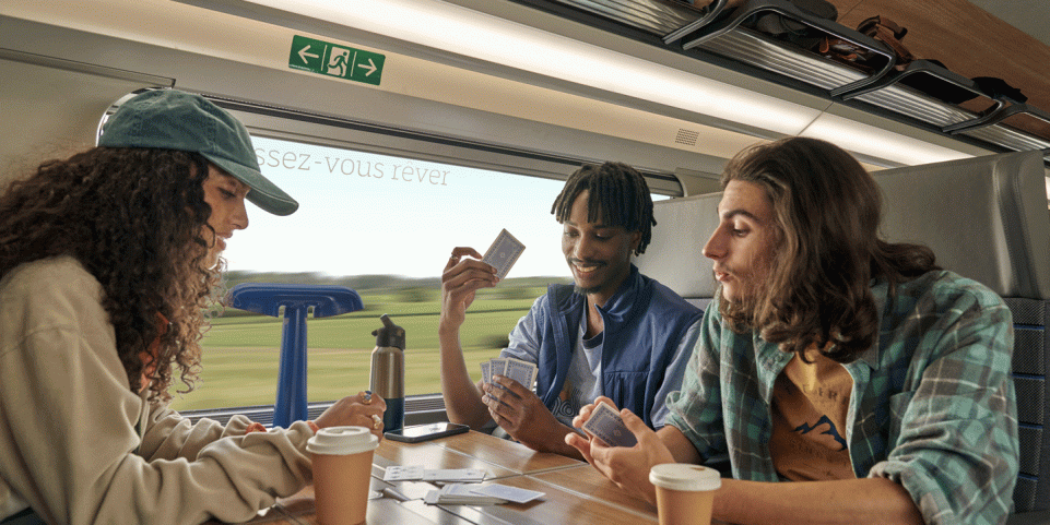 Groupe de copains jouant aux cartes à bord d'un TGV