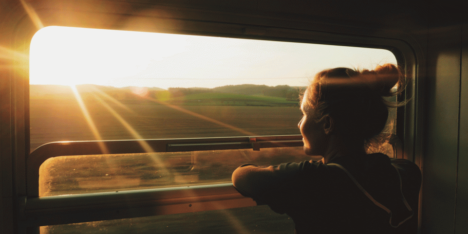 Femme qui regarde par la fenêtre à bord d'un train