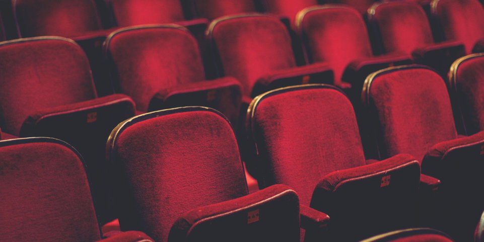 Des sièges rouges dans une salle de spectacle 