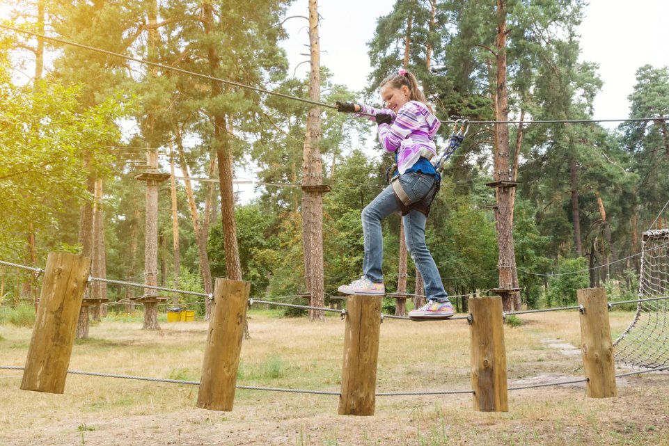 Jeune fille dans un accrobranche en forêt