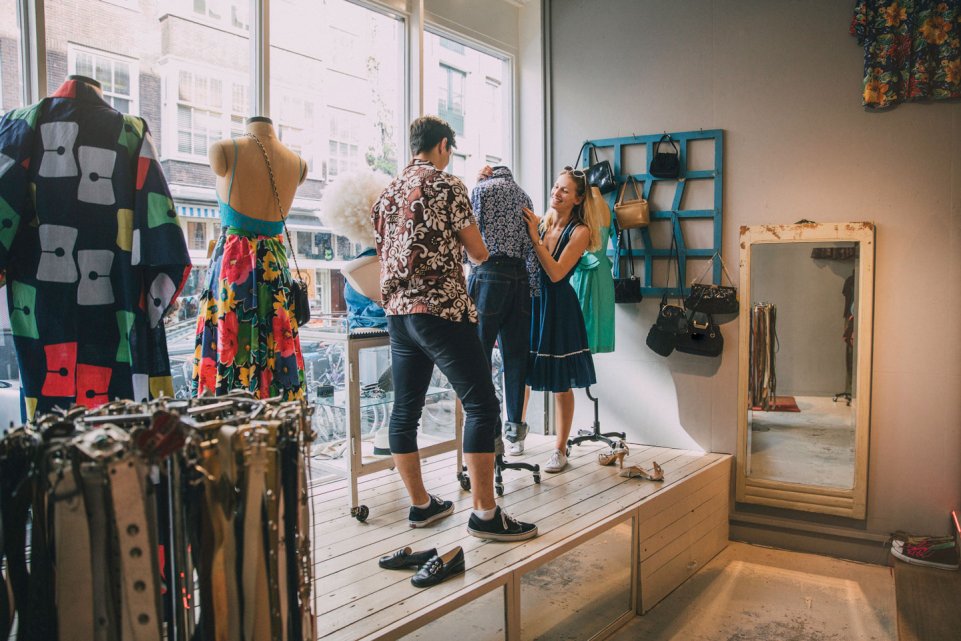 vendeurs habillent mannequin dans une boutique vintage 